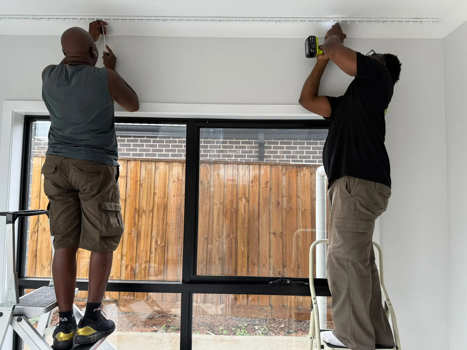 Two installers fitting a track