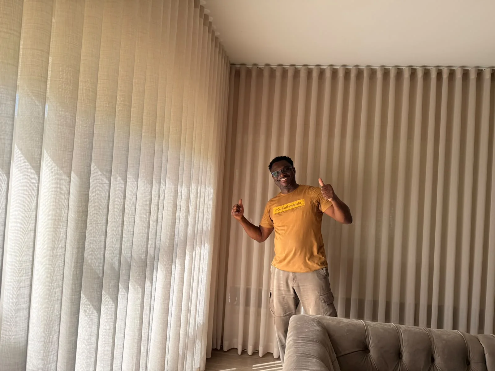 Final Touch owner standing beside installed curtains